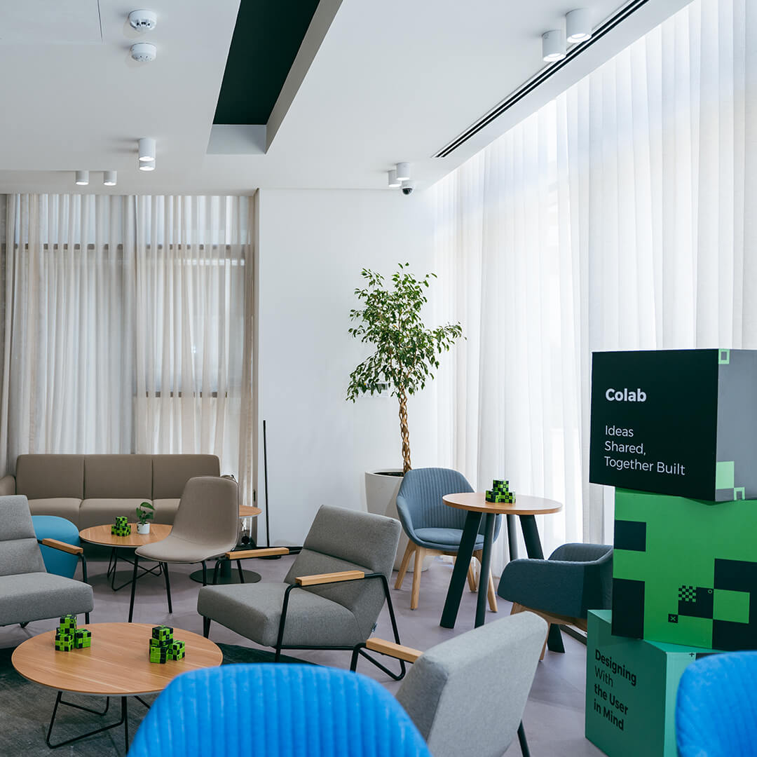 Bright lounge area with modern seating and stacked Colab-branded cubes.